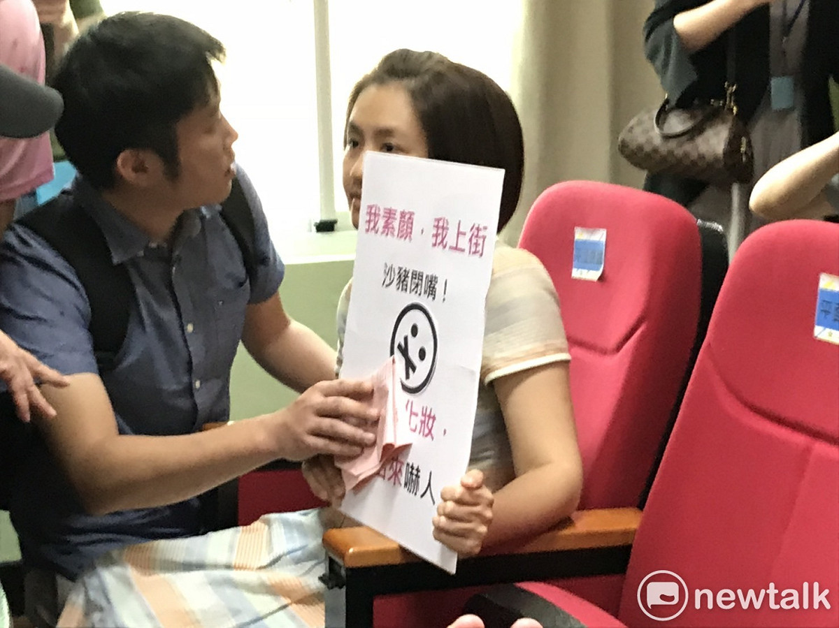 蔡宜珊手舉「我素顏，我上街」、「沙豬閉嘴」標語。 圖：周煊惠 / 攝