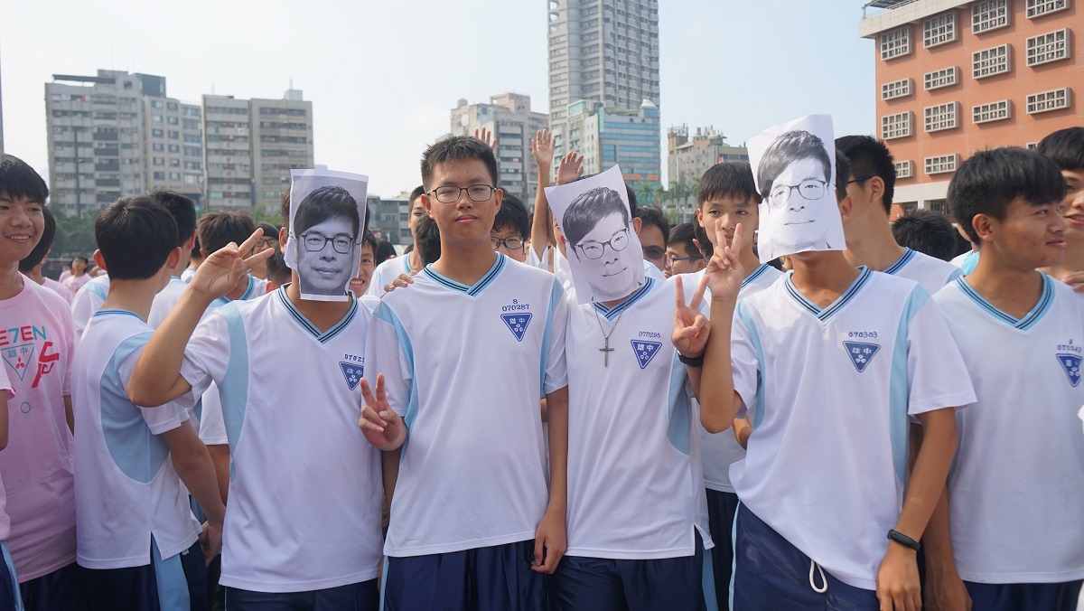雄中同學印製陳其邁臉部掛於臉上。 圖：陳其邁競選辦公室提供