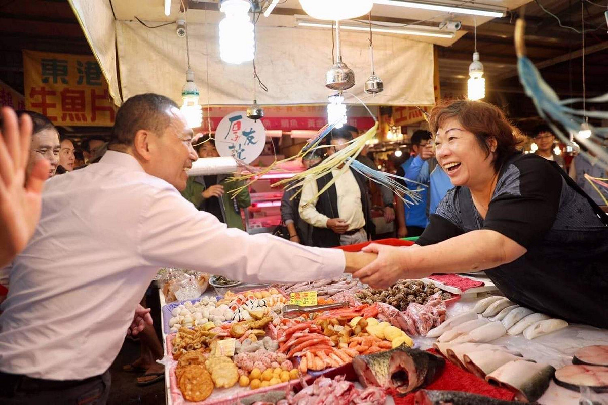 侯友宜前往鶯歌三元市場掃街拜票，攤商見到侯友宜立刻放下手邊工作搶著合照。 圖：侯友宜競選辦公室/提供