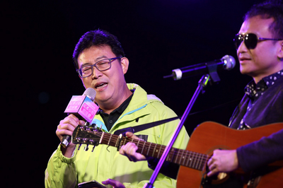 民進黨台北市長參選人姚文智（左）27日晚間為尋求連任的同黨議員阮昭雄站台，現場高唱「家後」一曲，獻給在背後默默支持他的太太。 圖：中央社