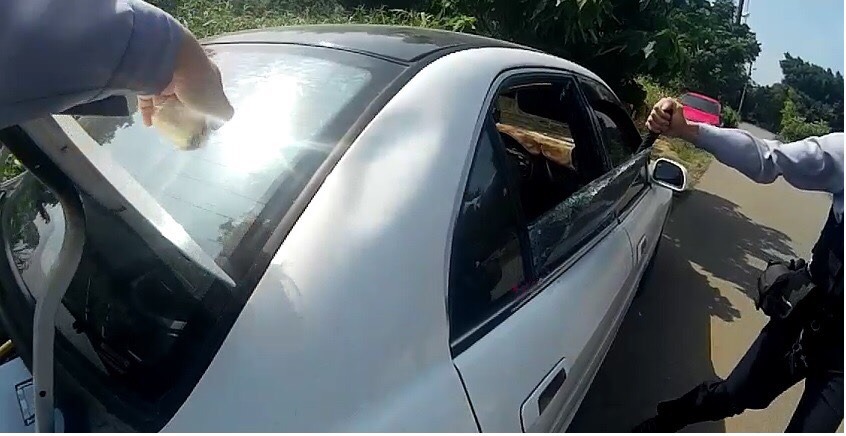 員警巡邏發現路邊有自用小客車排氣管連接一條水管，驚覺有人輕生，立即破窗救人。 圖：平鎮分局宋屋派出所／提供
