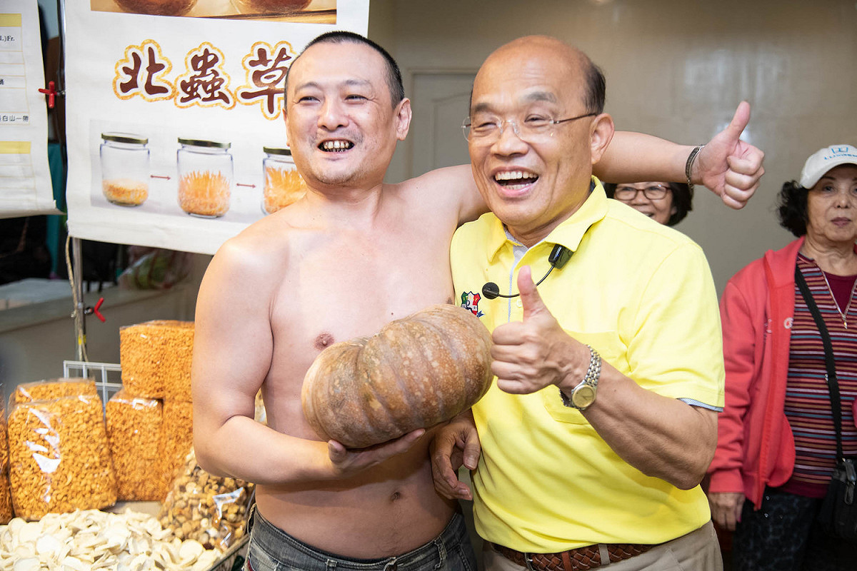 攤商拿出萬聖節應景的南瓜和蘇貞昌合影。 圖：蘇貞昌競選辦公室／提供