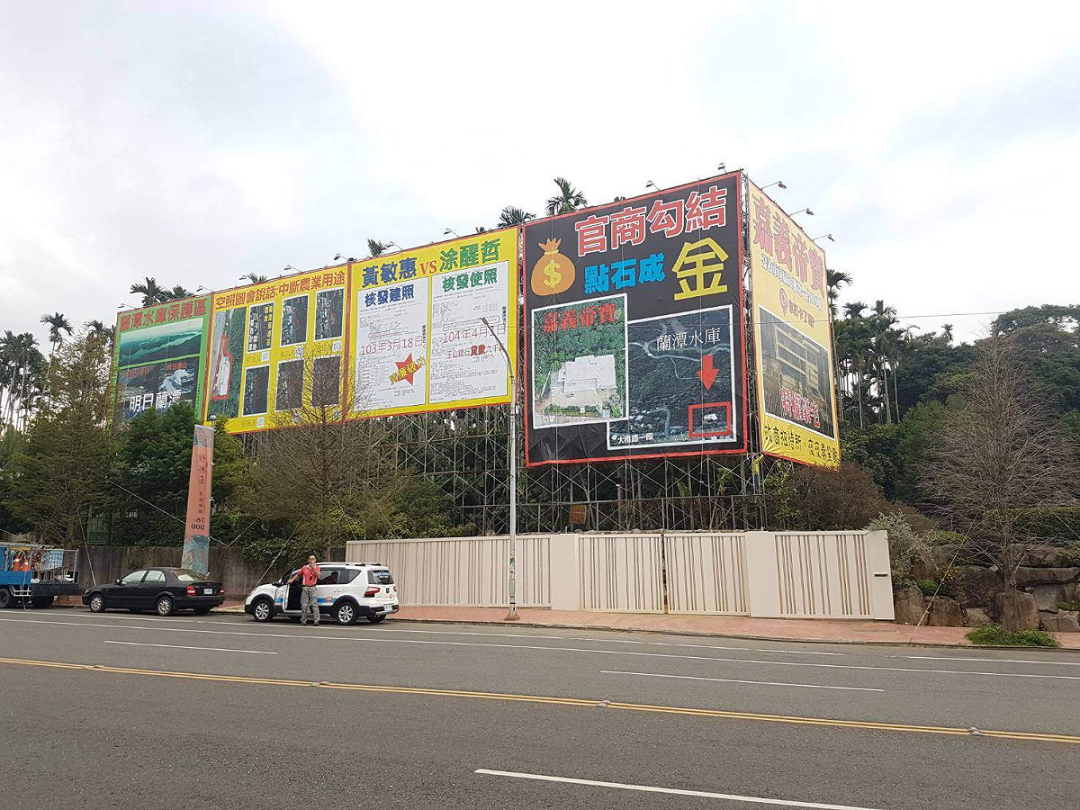 嘉義市建商黃朝雲位於大雅路上的豪宅旁，遭人架設廣告「指官商勾結，點石成金」。 圖：黃朝雲/提供