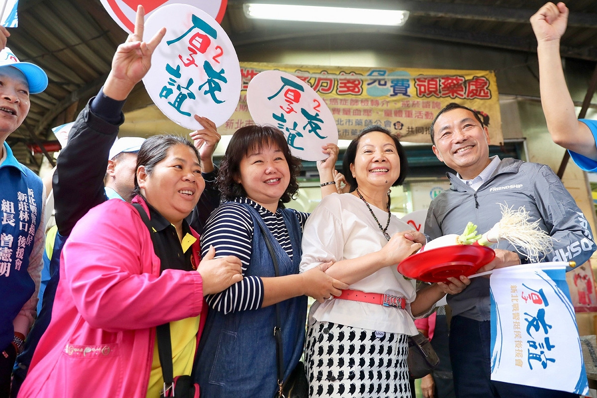 侯友宜31日前往新莊聯邦及裕民市場掃街拜票，攤商及支持民眾興奮搶著和他合照。 圖：侯友宜競選辦公室／提供