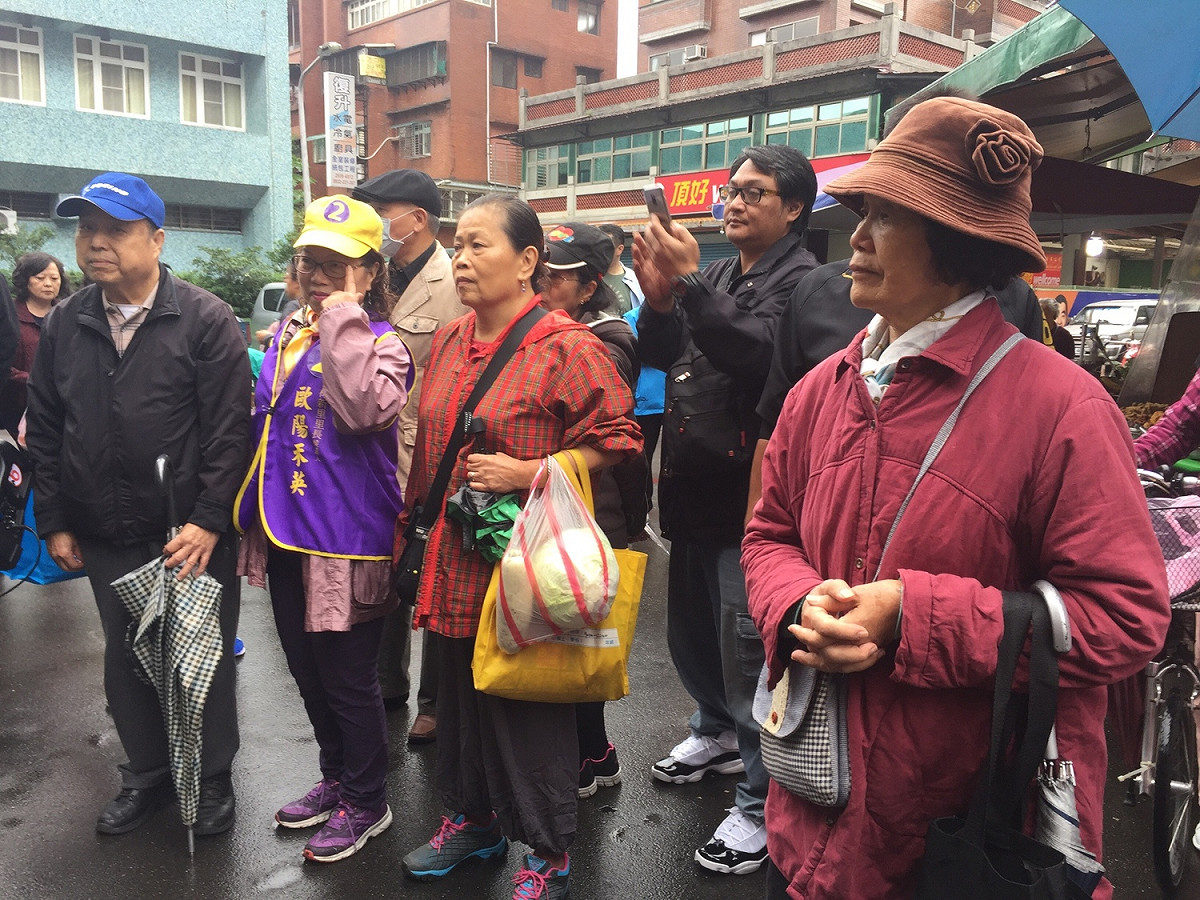 丁守中在木新市場大樓外進行簡短演講，吸引部分民眾駐足觀看聆聽。 圖：趙婉淳／攝