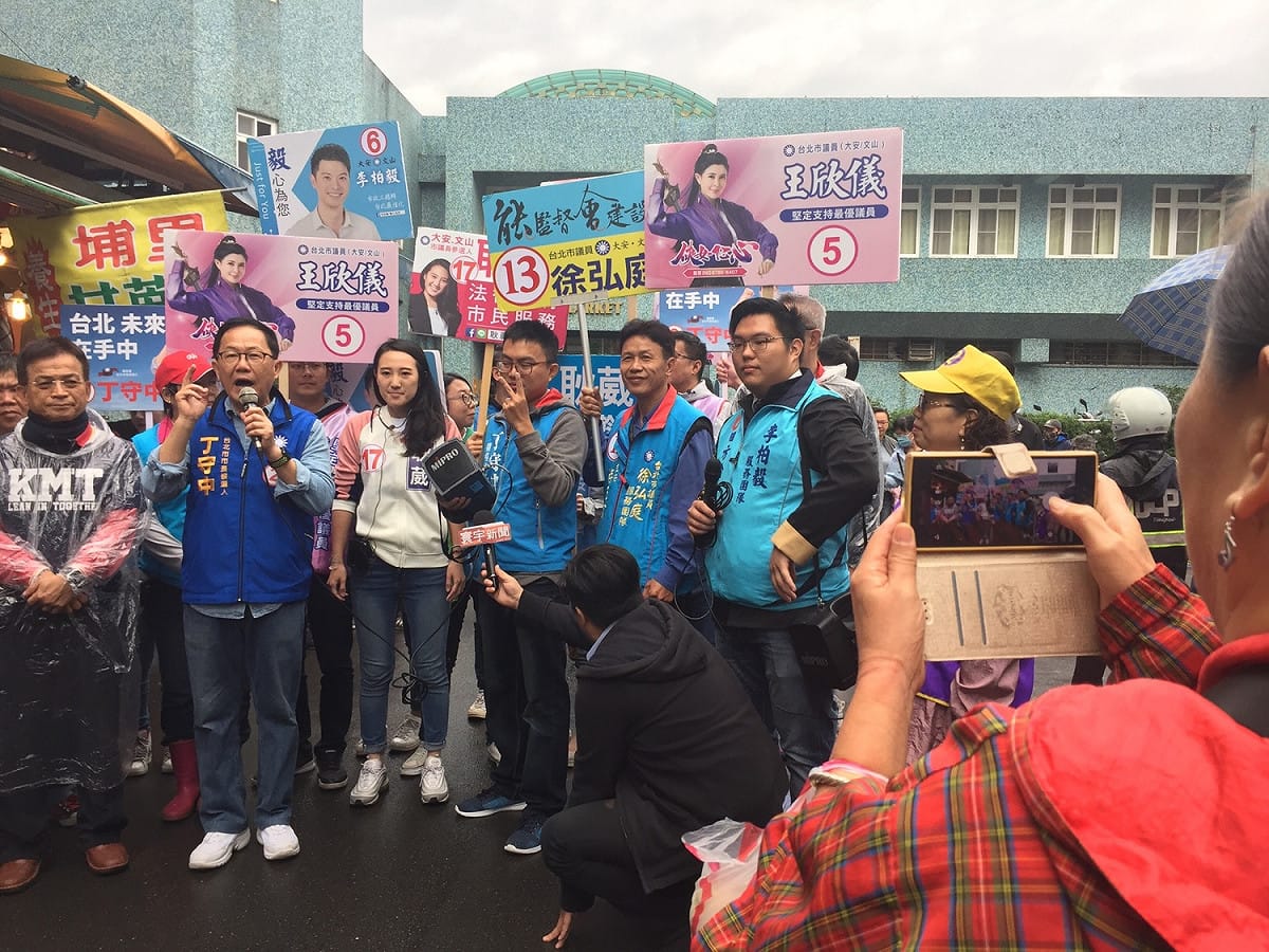 丁守中在木新市場大樓外進行簡短演講，甚至有熱情支持者也拿起相機拍攝紀錄下此時此刻。 圖：趙婉淳／攝