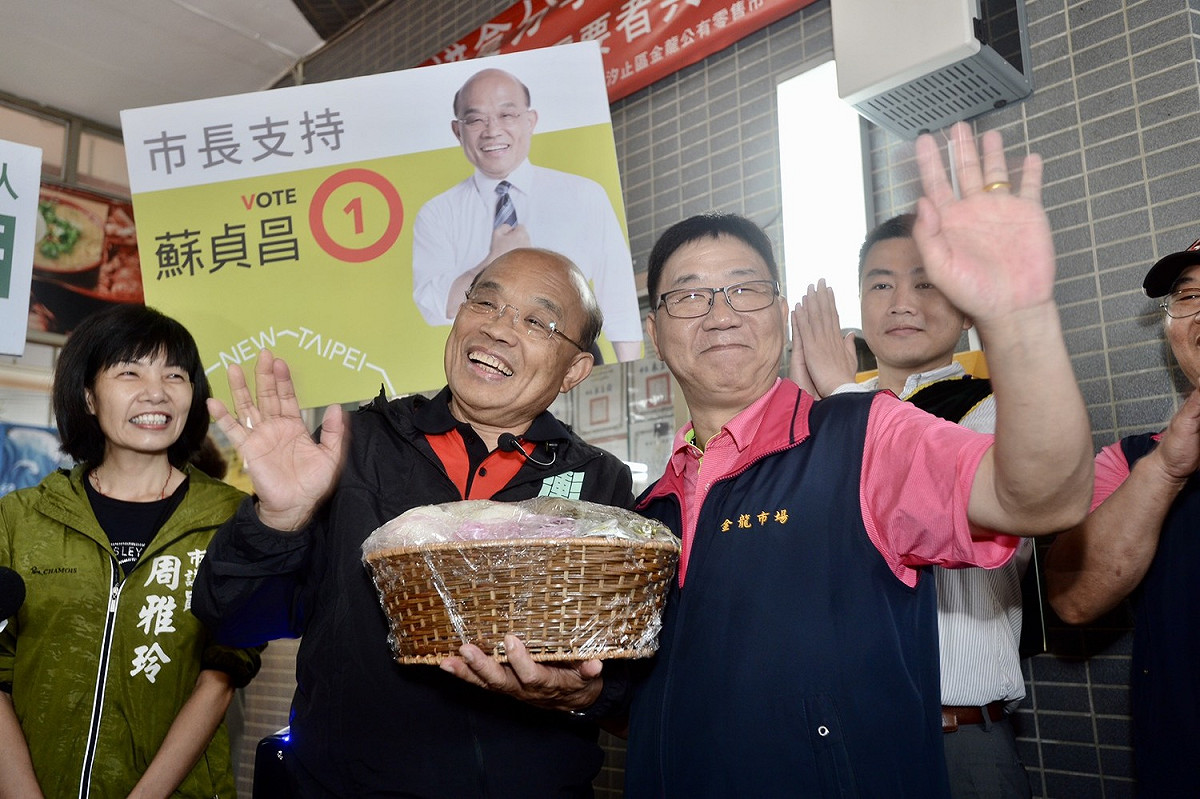 蘇貞昌今早到金龍市場掃街拜票，自治會會長率領所有成員送上一整籃的包子、粽子，祝福蘇貞昌能順利「包中」。 圖：蘇貞昌競選辦公室／提供