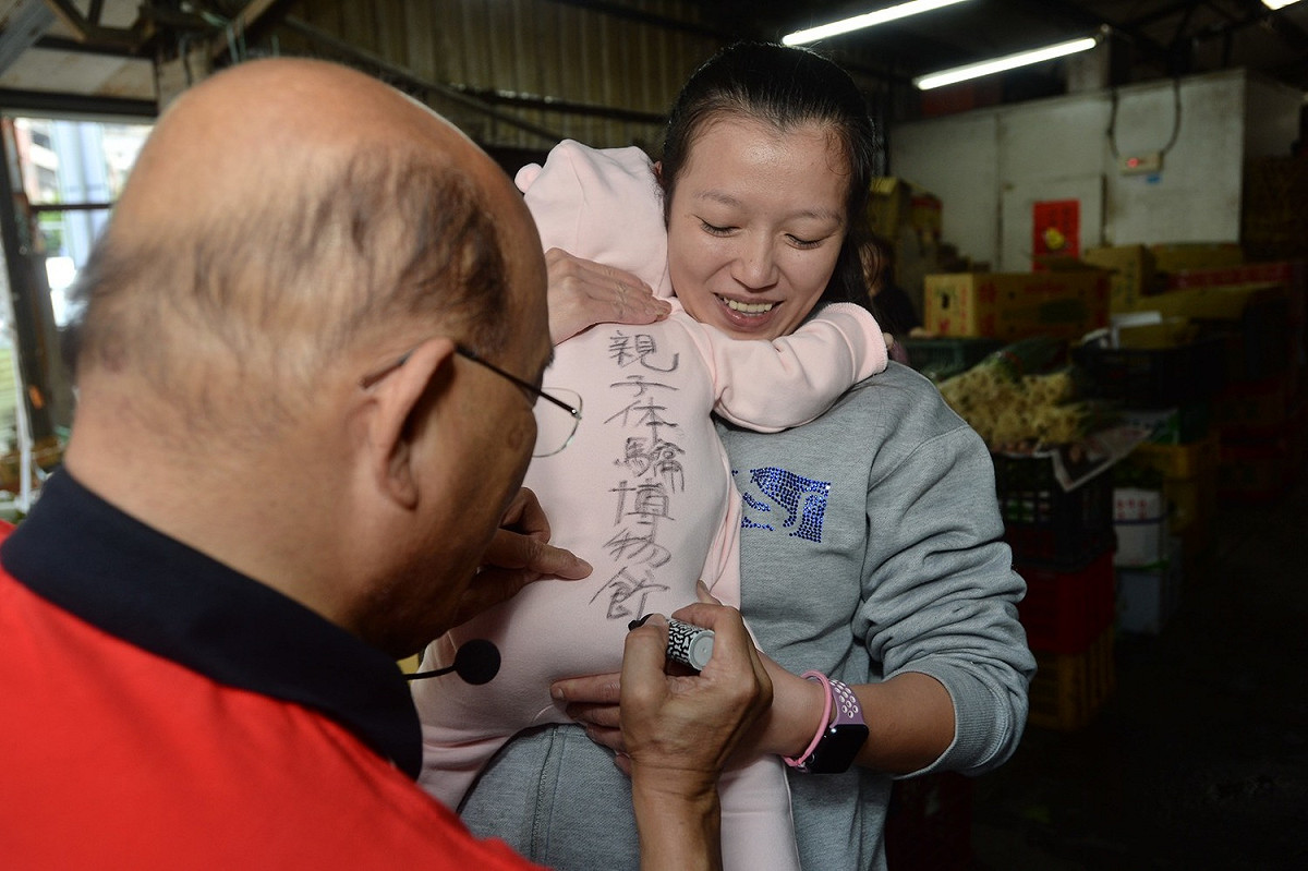 蘇貞昌在小朋友衣服簽上「親子體驗博物館，蘇貞昌！」，還允諾未來小朋友若帶這件衣服到親子體驗博物館，門票錢由他來出。 圖：蘇貞昌競選辦公室／提供