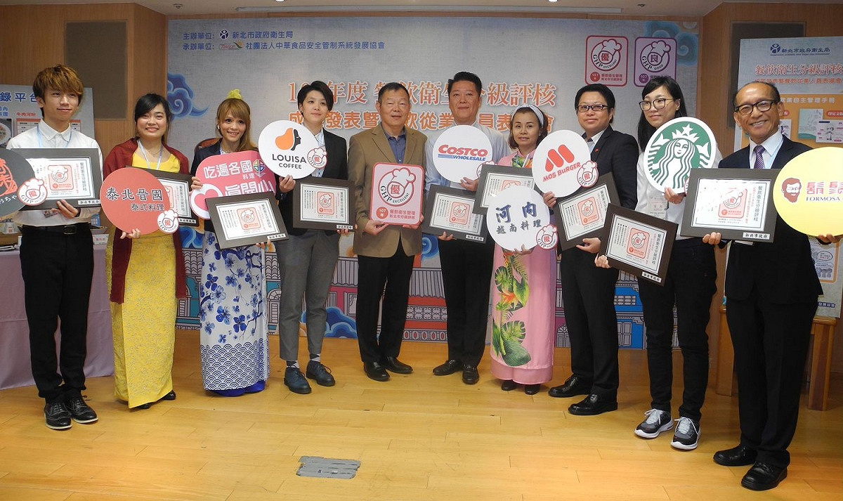 新北市衛生局今年輔導包括新住民餐飲業在內的503家業者通過分級評核，衛生局長林奇宏 (左五)頒發證書並與業者代表一起宣導。 
 圖：王峻昌/攝
