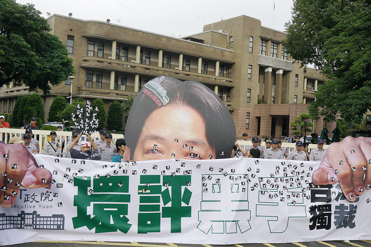 環團將一幅賴清德巨型頭像放在行政院大門口前，諷刺其獨裁專斷行事罔顧民意與環評專業。 圖：張良一/攝
