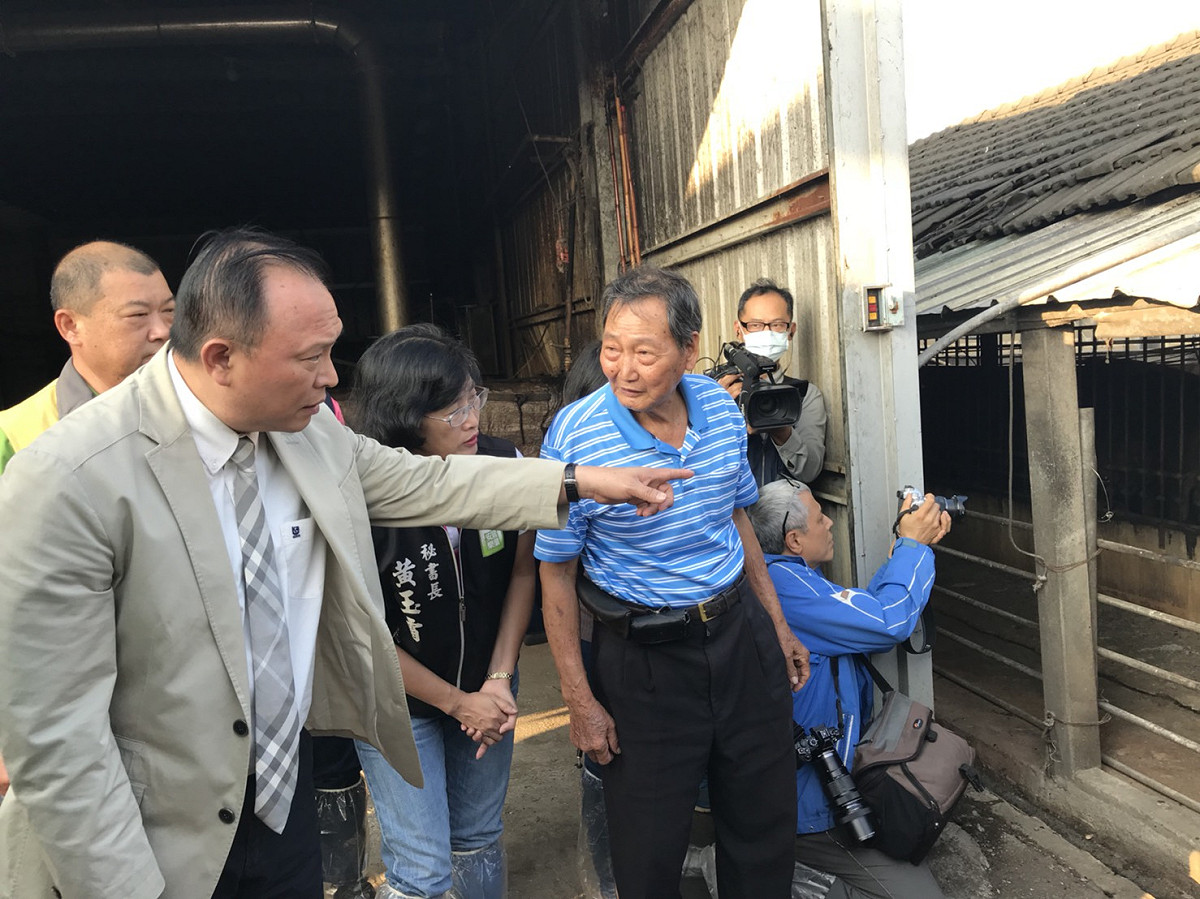 農委會主委林聰賢(左)與養豬場主廖憲平了解廚餘養豬過程 圖：農委會動植物防疫檢疫局/提供