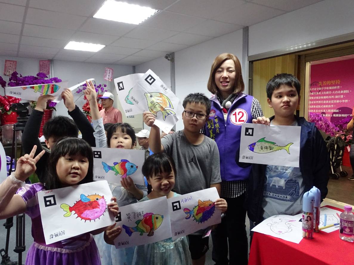 國民黨板橋區市議員劉美芳在競選總部陪著大人小孩塗鴉，一起玩互動投影科技。
 圖：劉美芳提供