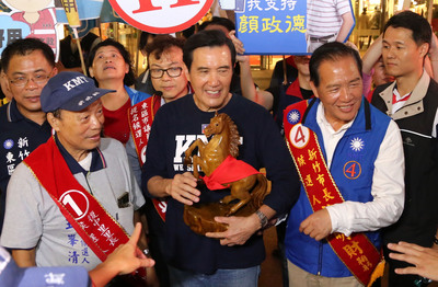 前總統馬英九（前中）4日晚間陪同國民黨新竹市長參選人許明財（前右）掃街拜票，並贈送一座木雕馬給許明財，祝他這次選舉「馬到成功」。 圖：中央社