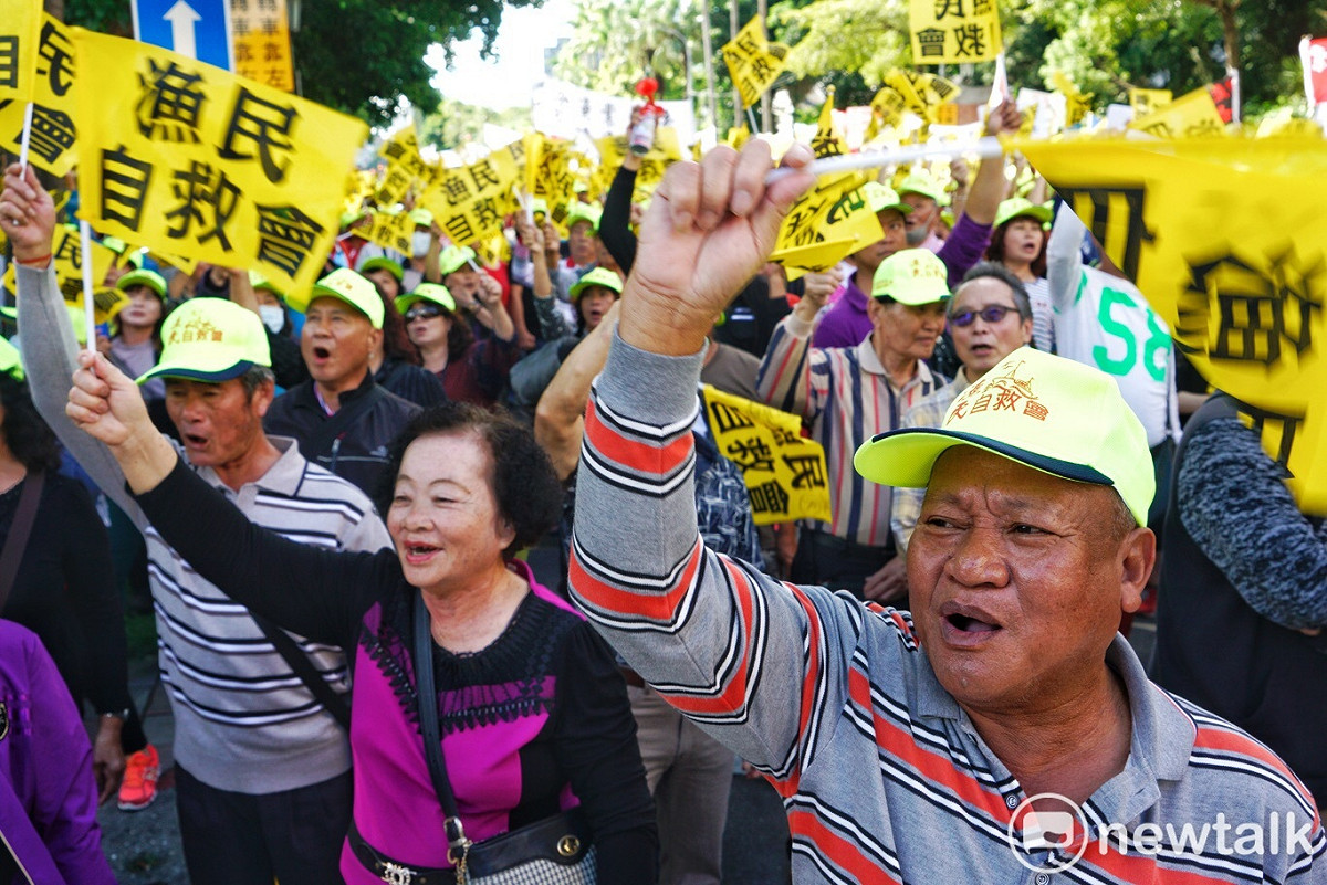 漁民自救會民眾高舉旗幟表達抗議。 圖：張良一/攝