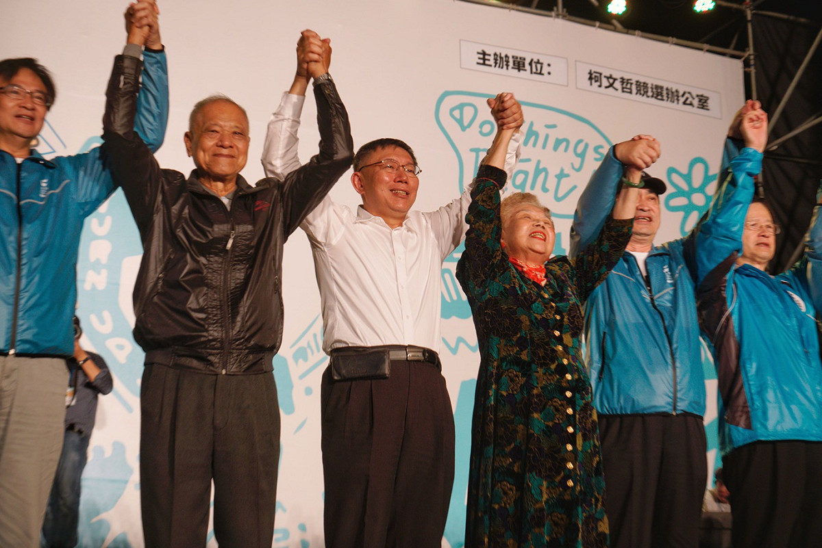 柯文哲、柯爸、柯媽和市府團隊高舉雙手向支持者致意。 圖：張良一/攝