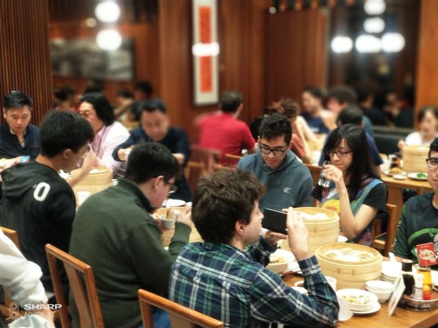 鼎泰豐菜單讓各國來賓大開眼界，邊吃邊拍照。 圖：金名/攝