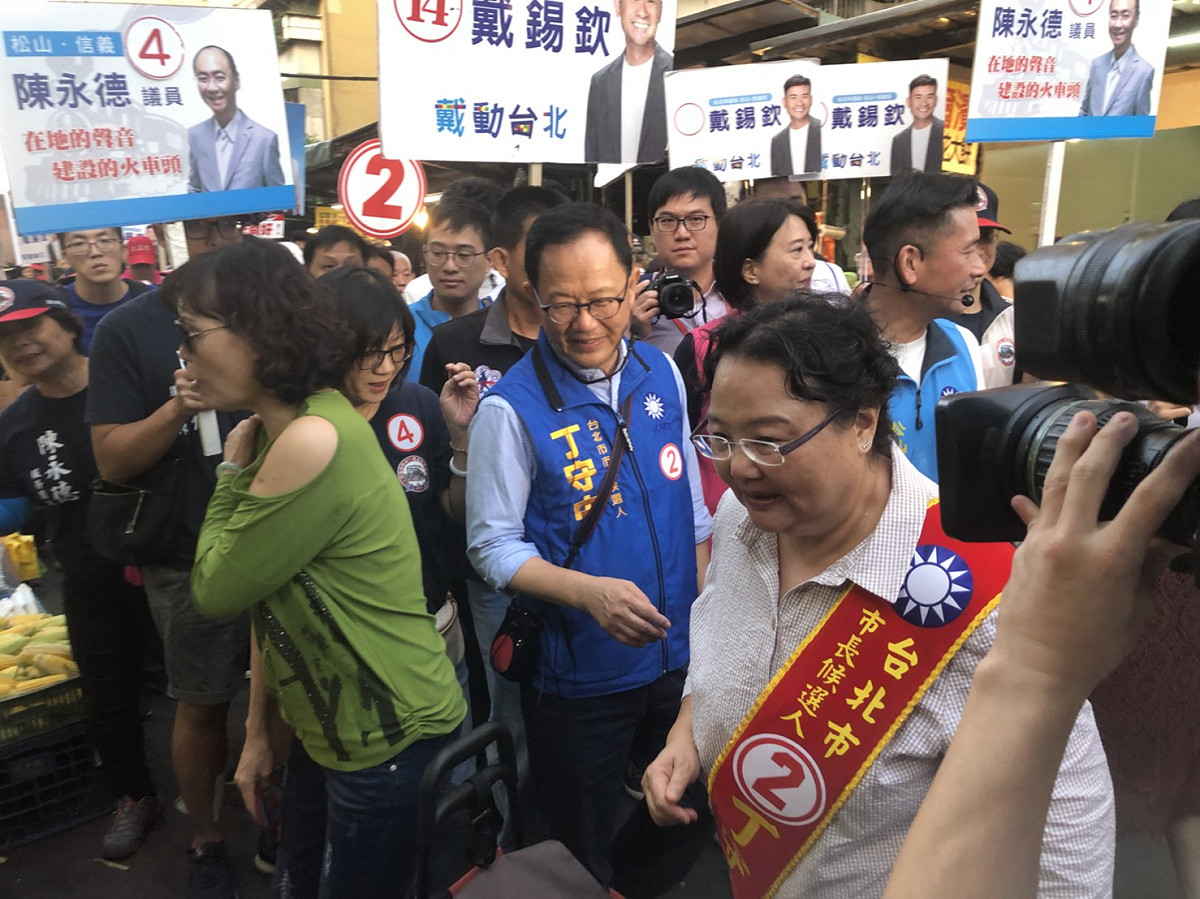 丁守中與溫子苓下午到永春市場掃街拜票。 圖：丁守中辦公室提供