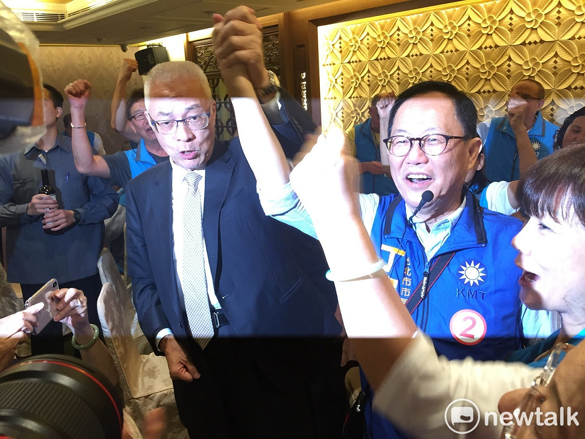 吳敦義牽起丁守中的手，高喊「凍蒜」。 圖：趙婉淳／攝