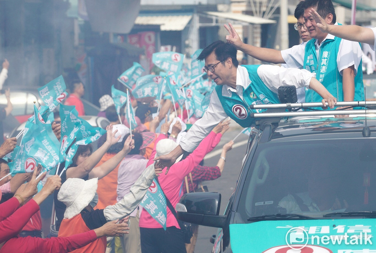 陳其邁站在宣傳車上握起路旁支持者的手。 圖：張良一/攝