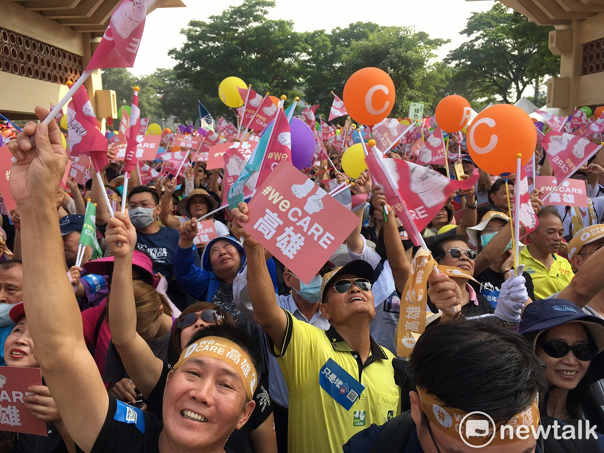 高雄WeCare氣球大遊行，高雄民眾舉起旗幟與氣球，抬頭望著天。 圖：張良一／攝