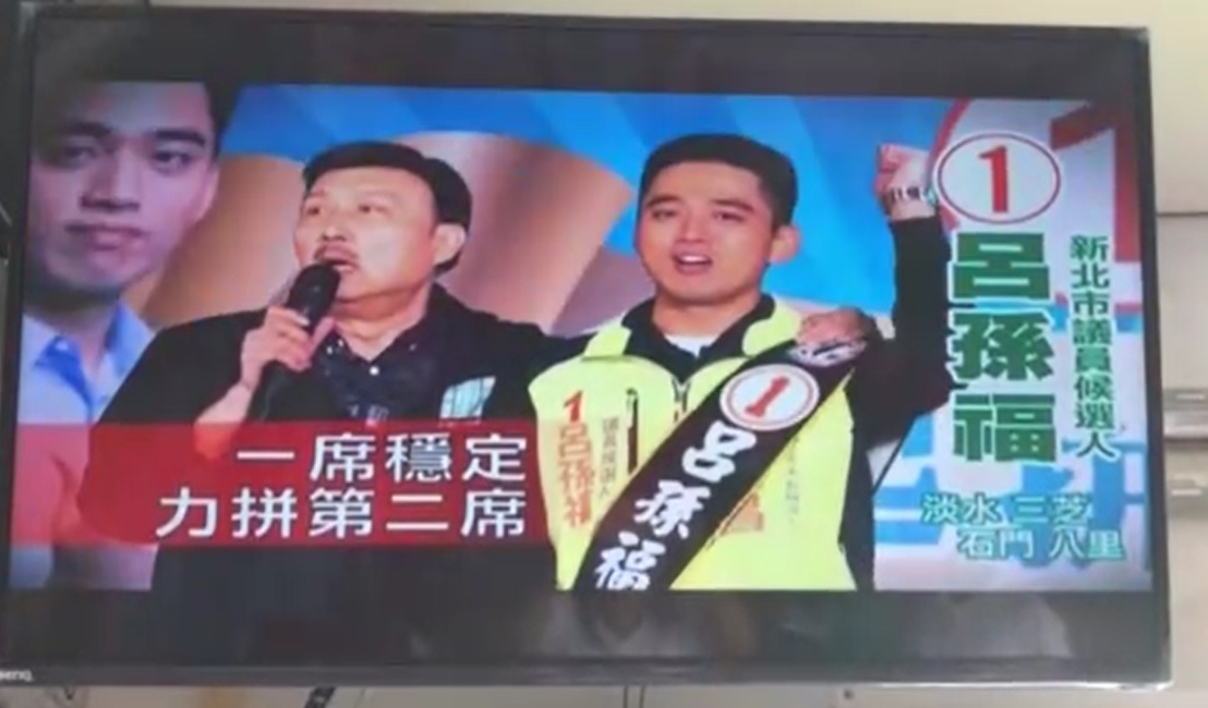 民進黨淡水區市議員候選人呂孫福，拿市黨部主委余天背書，推出「一席穩定，力拚第二席」電視廣告，引發爭議。 圖：王峻昌/翻攝