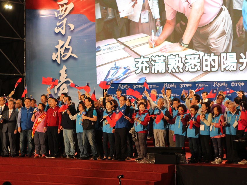 丁守中團隊齊聚於台上，用力揮舞國旗。 圖：趙婉淳／攝