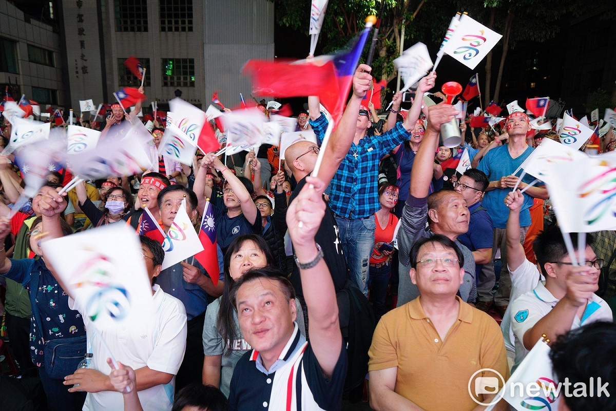 國民黨高市黨部前架設起大螢幕，轉播電視讓民眾看開票情形，現場原本擺放一千張椅子，但椅子一擺上，就陸續有民眾湧入，現場已幾乎坐滿。 圖：張良一／攝