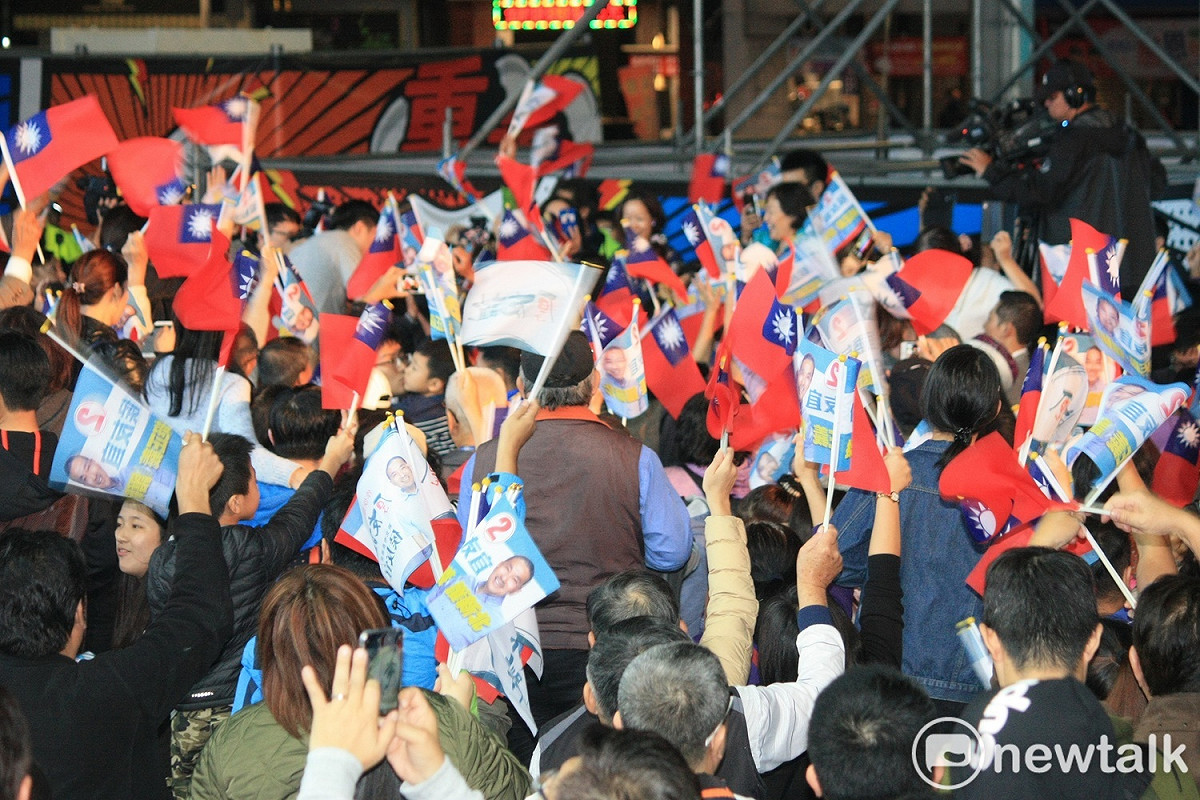 群眾緊盯大螢幕上各縣市開票結果，隨著選票陸續開出，熱情揮舞旗子。 圖：林昀真/攝