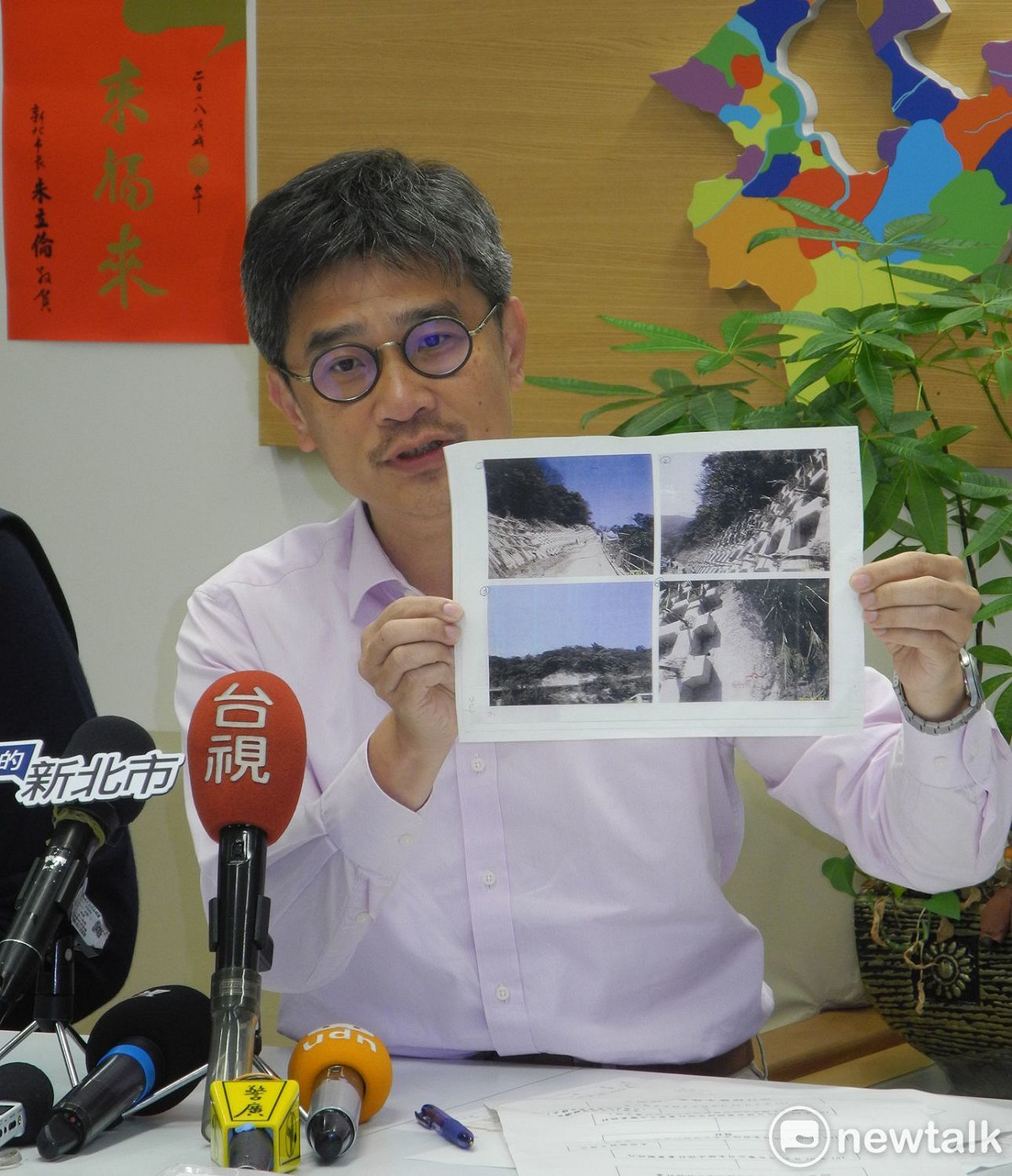 新北市農業局長李玟出示去年0602豪大雨，核一廠邊坡土石崩塌的情況。 圖：王峻昌/攝