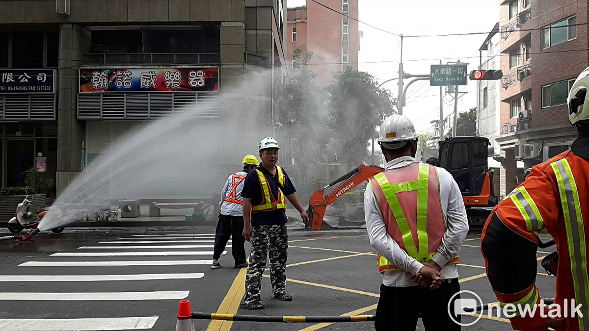桃市大業路驚傳瓦斯管線四天挖斷兩次，濃濃瓦斯味瀰漫空氣中，警消現場拉水線戒備，並先灑水預防意外發生。 圖：林昀真／攝