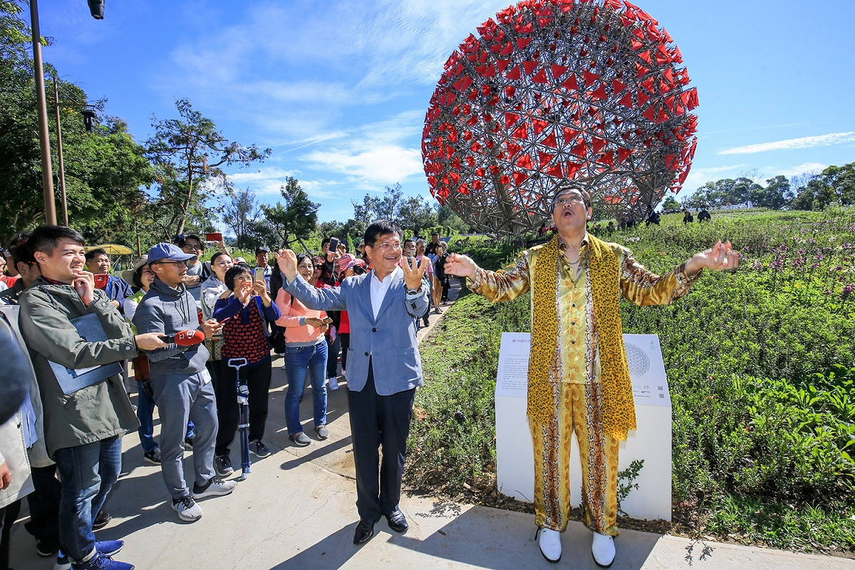 piko太郎在「聆聽花開的聲音」機械花球前與林市長大跳《PPAP》。 圖：取自台中市政府網頁