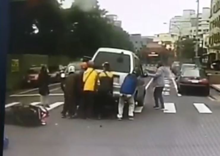 眾人合體將廂型車抬起，讓困在車底下的傷者移出後送醫。 圖：翻攝臉書社團「爆料公社」