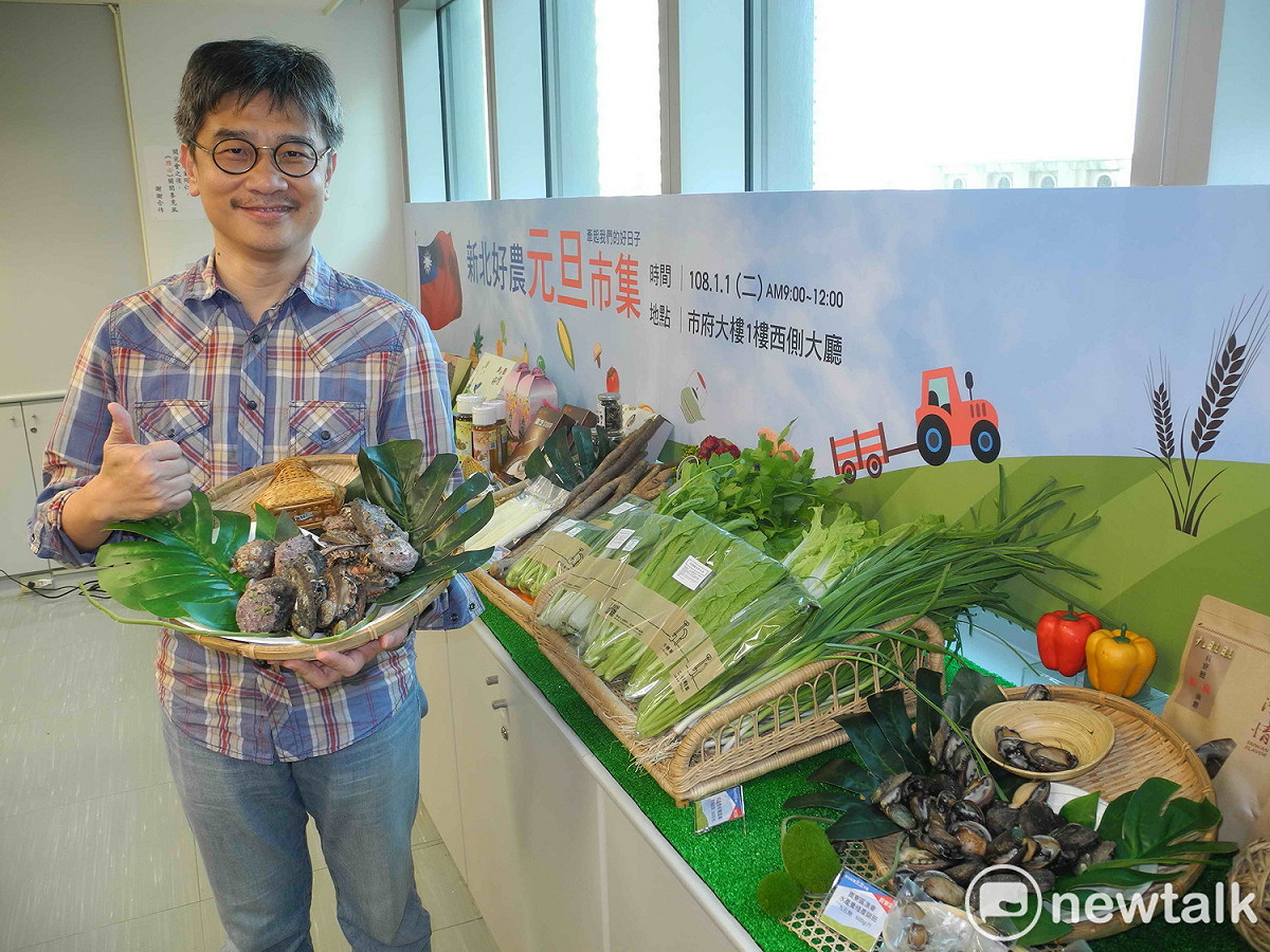 新北市農業局長李玟展示元旦升旗典禮的農漁產市集，包括貢寮鮑、有機農產品。 圖：王峻昌/攝