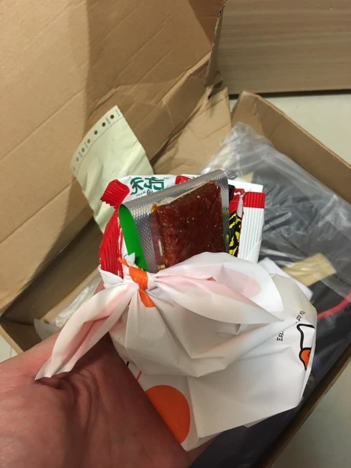 有民眾在淘寶網購衣服，打開箱子竟發現裡頭多了一包疑似豬肉乾的物品。有網友痛批根本就是「生化攻擊」。 圖：翻攝自PTT