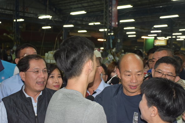 韓國瑜在媒體簇擁下與農業局長吳芳銘（左）視察果菜市場。 圖：孫家銘/攝