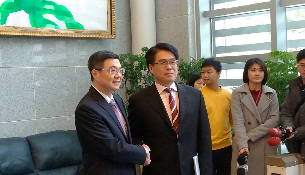 卓榮泰與游盈隆握手。 圖：陳佩君／攝