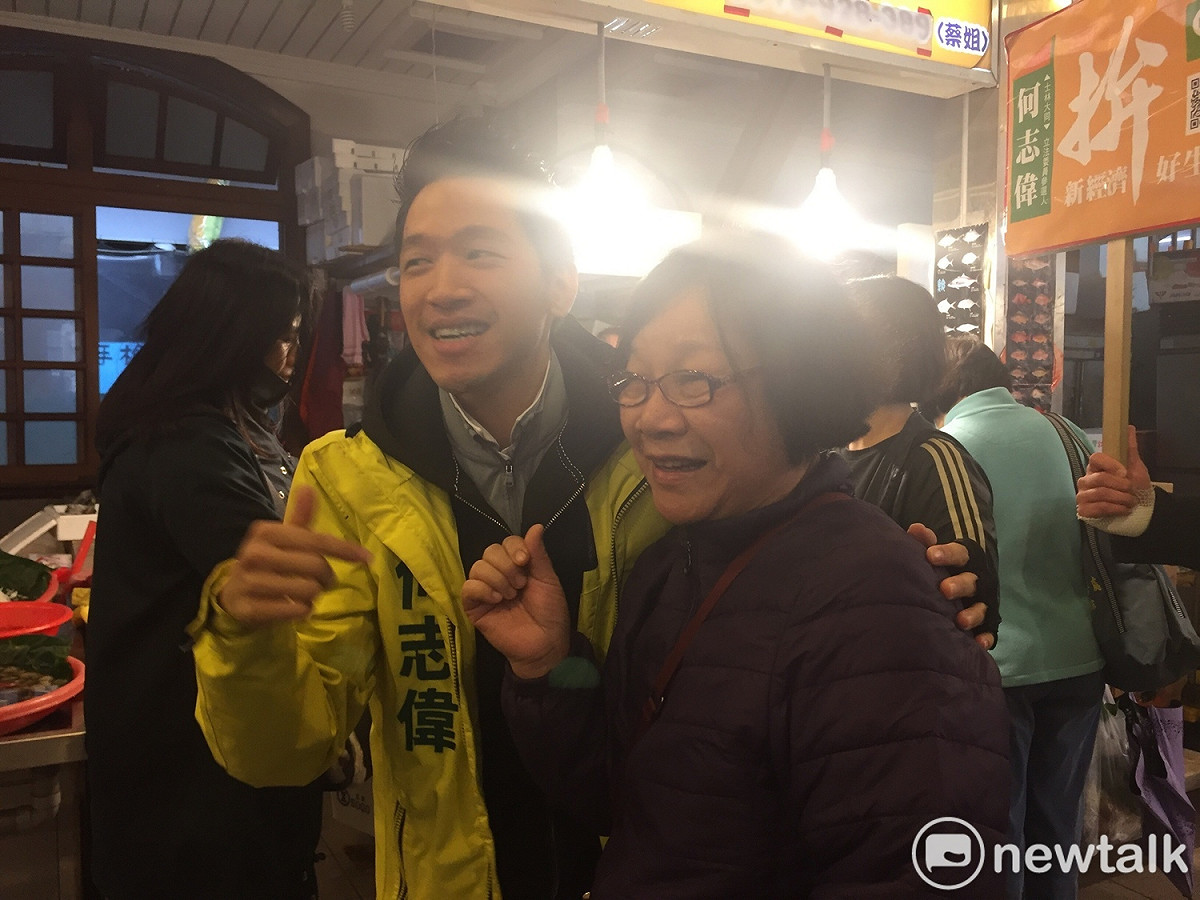 前北市議員何志偉上午到士林市場掃街拜票，面對民眾，何主動向攤商擁抱。 圖：趙婉淳／攝