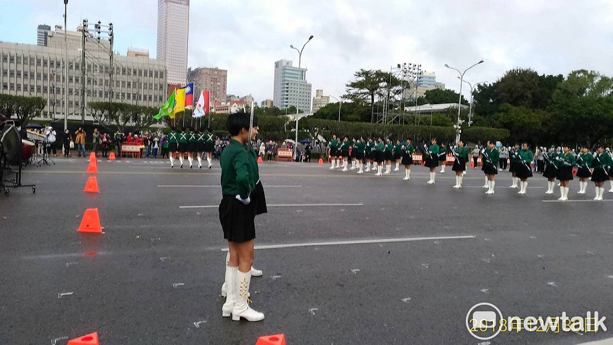 近日冷氣團發威，台灣氣溫驟降，北一女儀隊、建中樂旗隊不畏低溫細雨，下午在凱道前整齊劃一地操槍跳舞。 圖：趙婉淳／攝