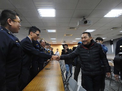 板橋28日下午發生銀行強盜案，板橋警方短短28小時就 破案逮人，警界出身的新北市長侯友宜（右）30日上午 前往板橋分局慰勞破案有功人員，一一握手致意。 圖：中央社