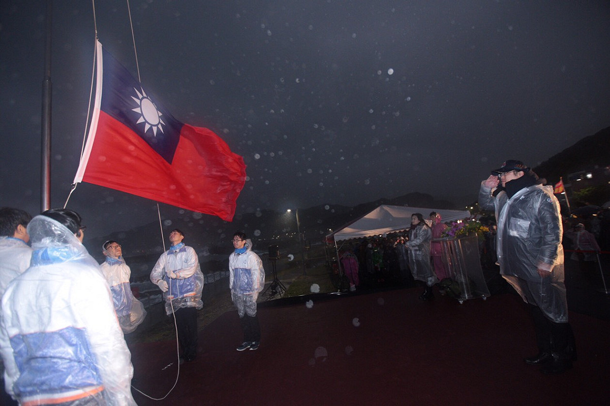 升旗典禮遇著惡劣天氣，暖暖高中的學生擔任升旗手。 圖：基隆市政府提供