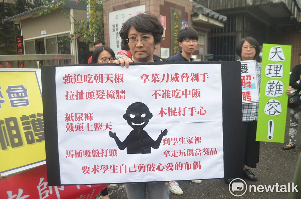 人本基金會舉牌列舉女童遭施暴的恐怖內容。 圖：蔡坤龍/攝