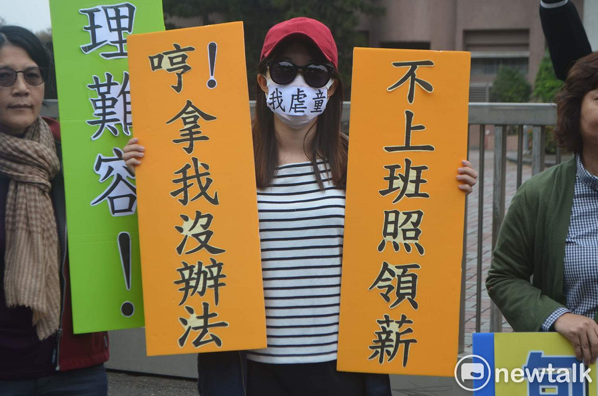 人本基金會舉牌諷刺虐童者繼續爽領薪水。 圖：蔡坤龍/攝