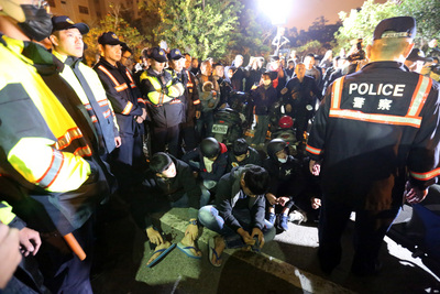南1歲多女童疑遭虐死，4名涉案人陸續被裁定收容或 收押；因南檢外民眾群聚，檢院警17日凌晨採調虎離山 之計，送走嫌犯；6名呼嘯而過的騎士則遭警方壓制， 就地管制。 圖：中央社