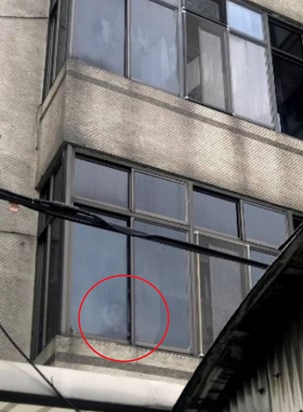 印尼看護工阿娣在站在二樓窗戶揮手求救。 圖：新北市勞工局/提供