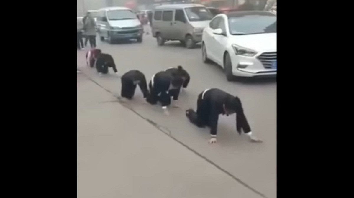 中國山東一間公司迫使女員工街頭集體跪地爬行，引發民眾與警方關注。 圖：翻攝自youtube