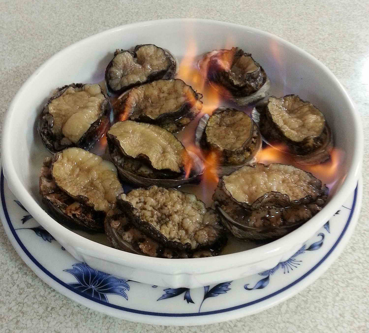 高粱酒炙燒的貢寮鮑，是貢寮產地餐廳才吃的到的新鮮料理。 圖／漁業及漁港事業管理處提供