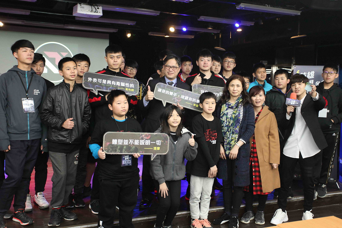 新北市副市長吳明機(中)、Ahq職業選手劉書瑋(中右)、Ahq職業選手康家維(中左)及英雄聯盟冬令營學員共同合影。 圖：新北市政府經發局提供