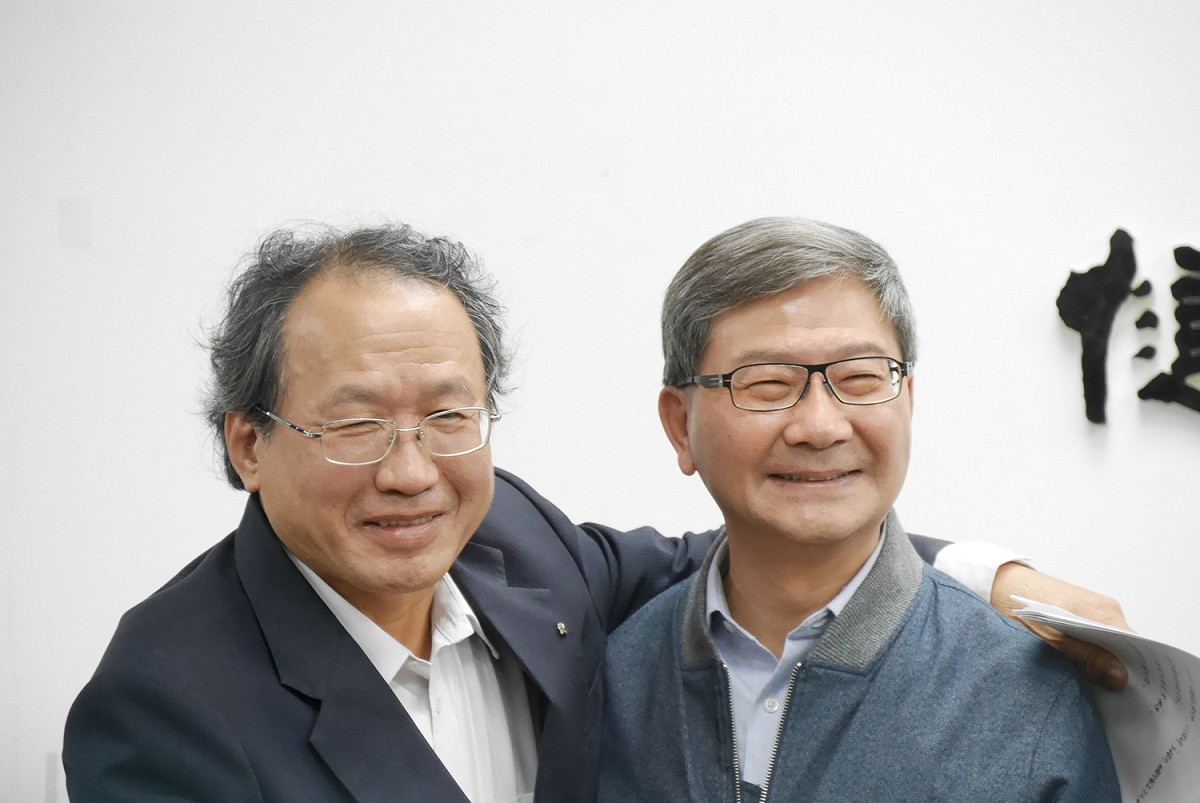 農委會副主委黃金城（左）與環保署副署長沈志修（右）擁抱致意，強調兩個單位「一條心」，溝通良好。 圖：防檢局