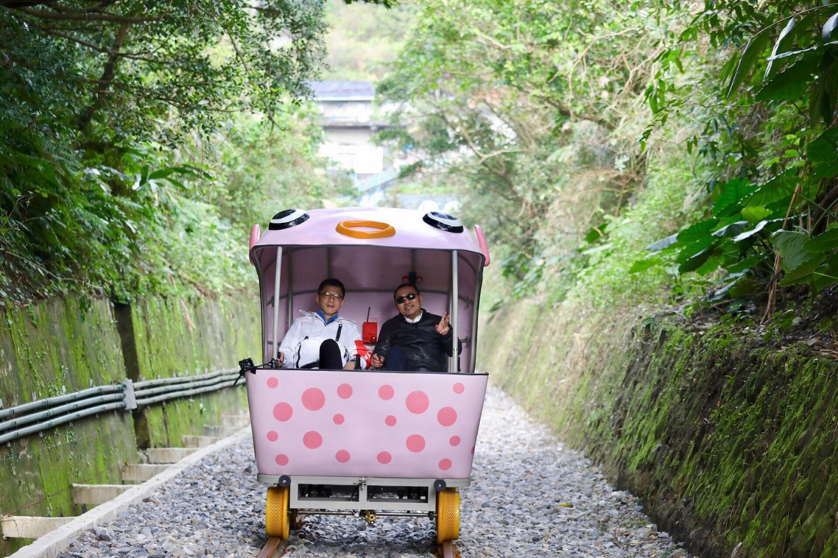 新北市長侯友宜和觀旅局長張其強合力腳踩自行車，體驗深澳鐵道自行車道的風光。 圖：新北市政府觀光旅遊局／提供