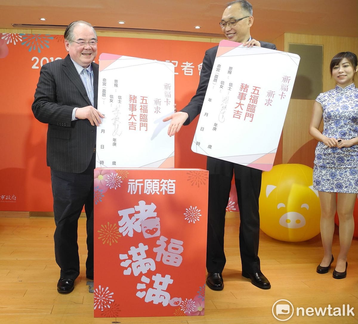 三重宗教文化交流協會理事長李乾龍（左）、新北市副市長謝政達示範締結良緣祈願卡，簽上自己的心願後投入祈願箱。  圖：王峻昌/攝